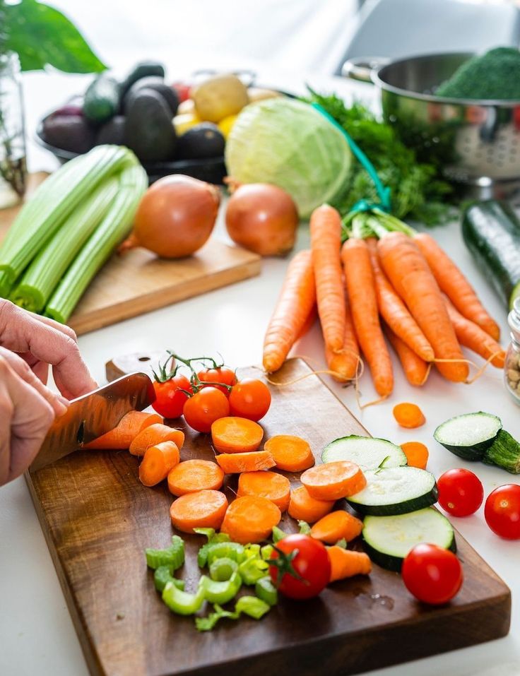 Assorted seasonal vegetables and fruits arranged on a wooden board for meal planning